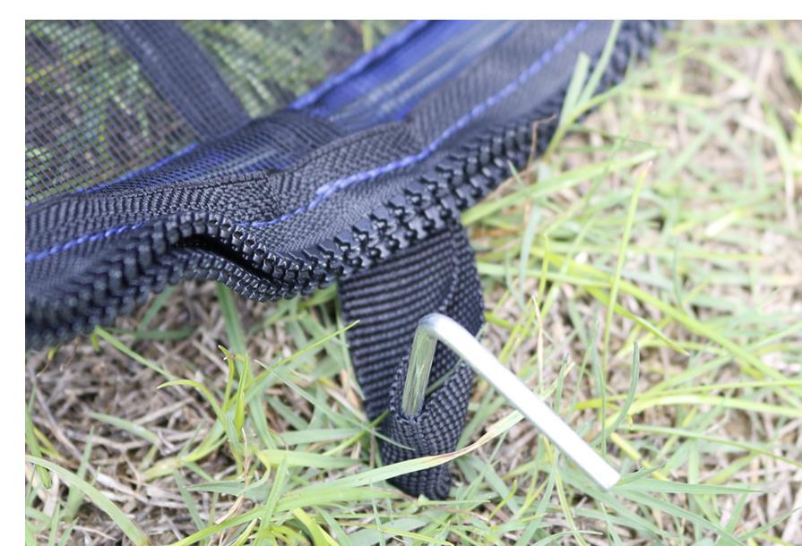 Ground stake and zipper detail on outdoor cat playpen
